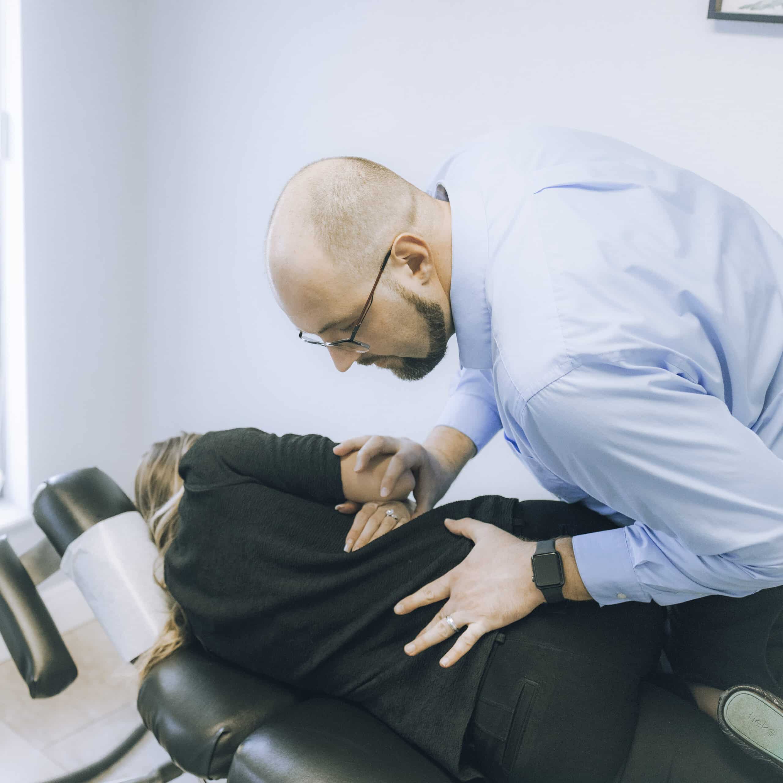 Dr. Kyle performing chiropractic adjustment on Dr. Amy Kerr