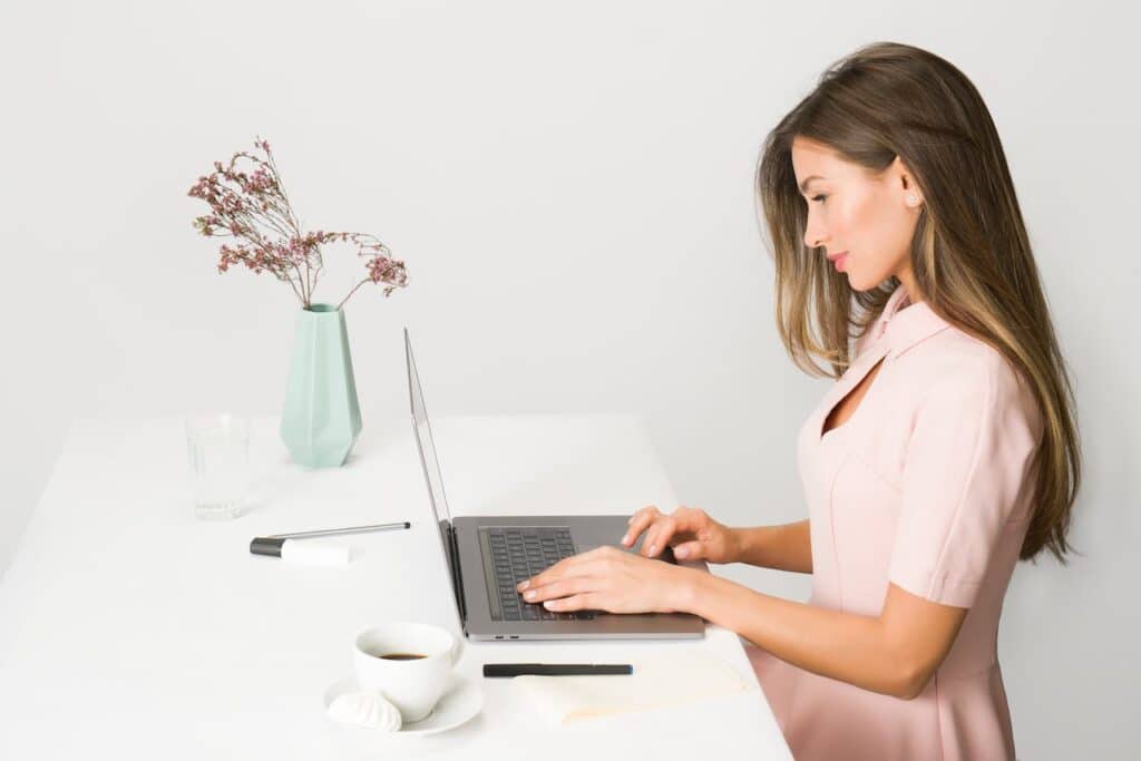 woman sitting straight while using laptop